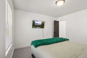 Bedroom with light colored carpet and baseboards