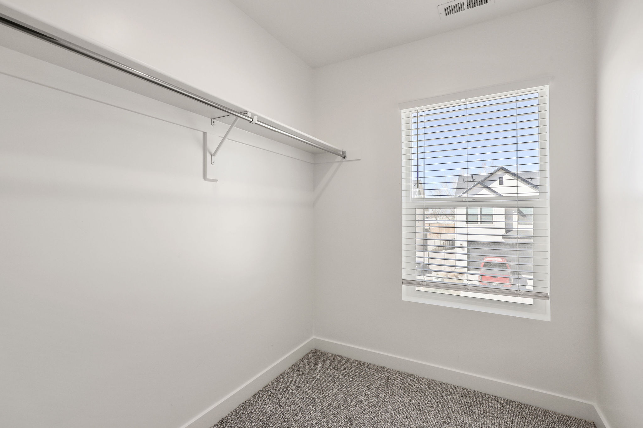 Walk in closet with light carpet