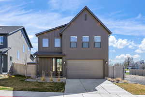 View of front of house with board and batten siding, concrete driveway, and an attached garage