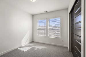 Spare room with light carpet and baseboards