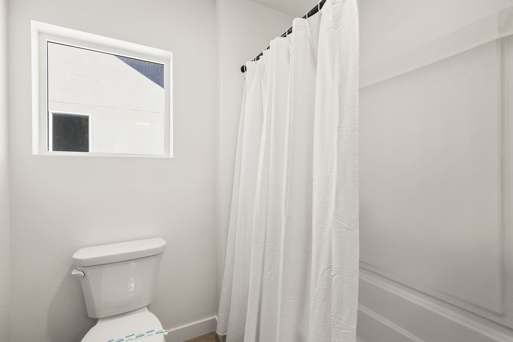 Bathroom featuring a shower with shower curtain and toilet