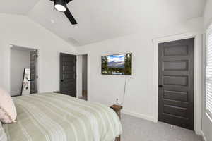 Bedroom with light colored carpet, vaulted ceiling, and ceiling fan
