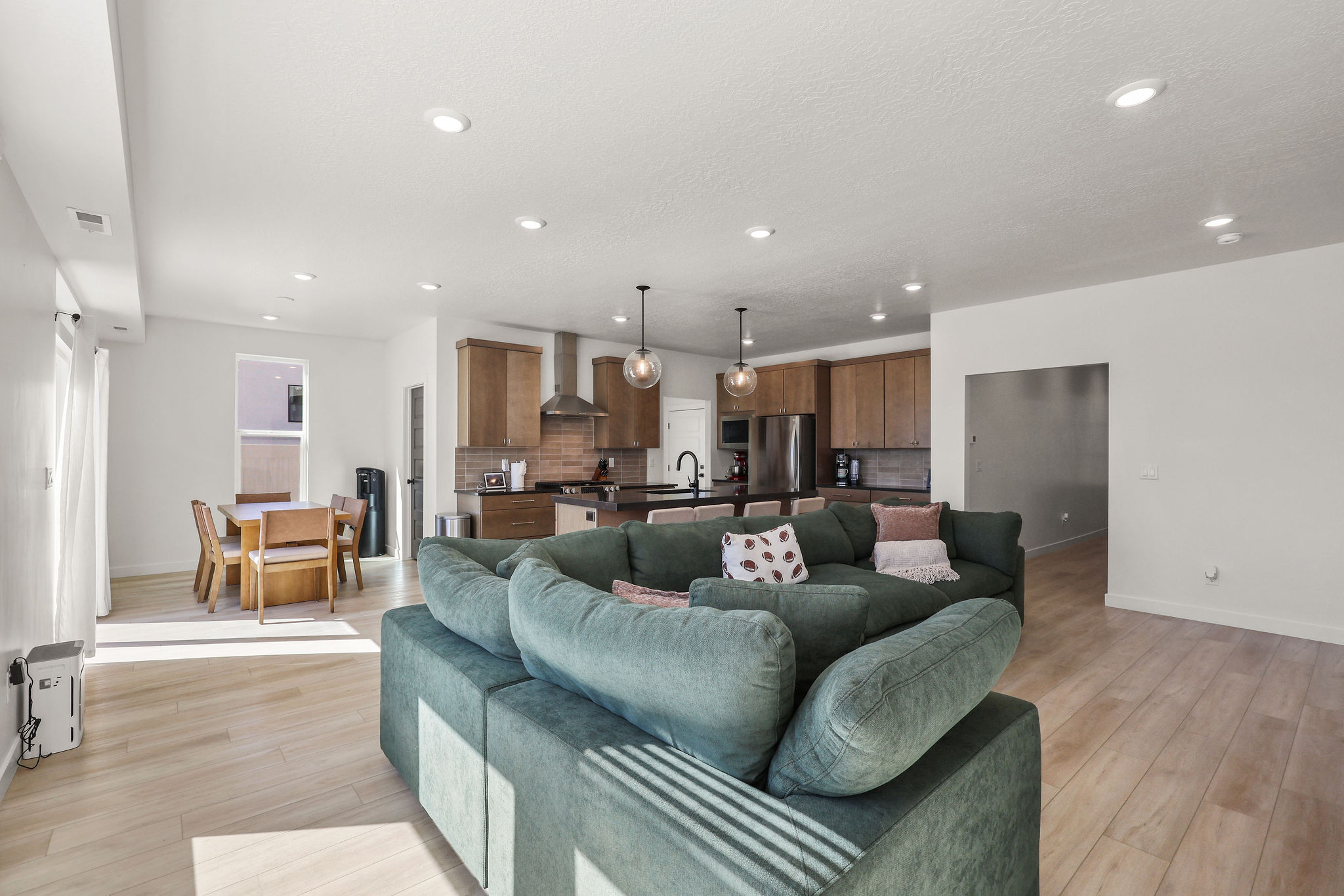 Living area with light wood-style flooring and recessed lighting