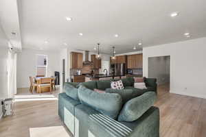 Living area with light wood-style flooring and recessed lighting
