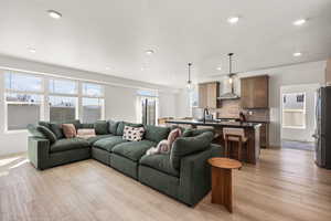 Living room with light wood-type flooring, a textured ceiling, and recessed lighting