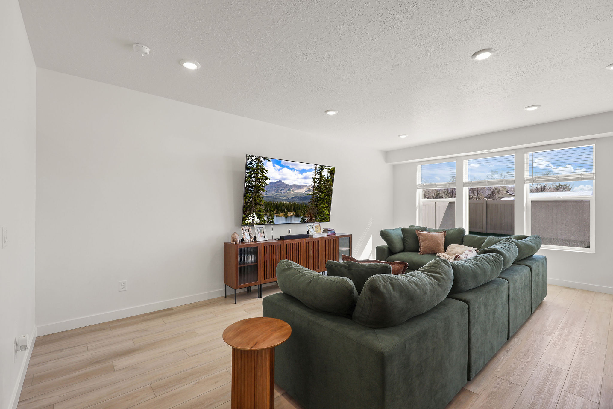 Living room with light wood-style flooring, a textured ceiling, and recessed lighting