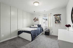 Bedroom featuring carpet and a textured ceiling