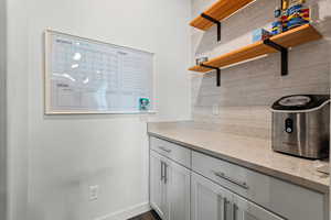 Laundry room featuring baseboards and dark wood finished floors