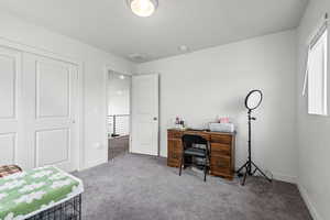 Office space with light carpet and a textured ceiling