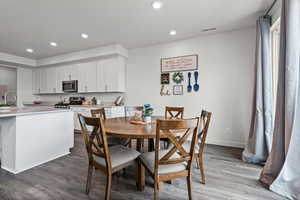 Dining room featuring dark wood-style floors and recessed lighting