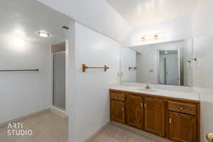 Full bathroom with a stall shower, vanity, a textured ceiling, and light tile patterned floors