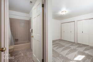 Bathroom featuring shower / tub combo with curtain and light colored carpet