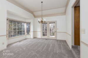 Unfurnished dining area featuring suspended lighting, ornamental molding, light carpet, and lofted ceiling