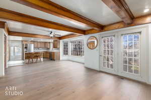 Living area featuring a textured ceiling, light wood-style flooring, ceiling fan, beamed ceiling, and recessed lighting