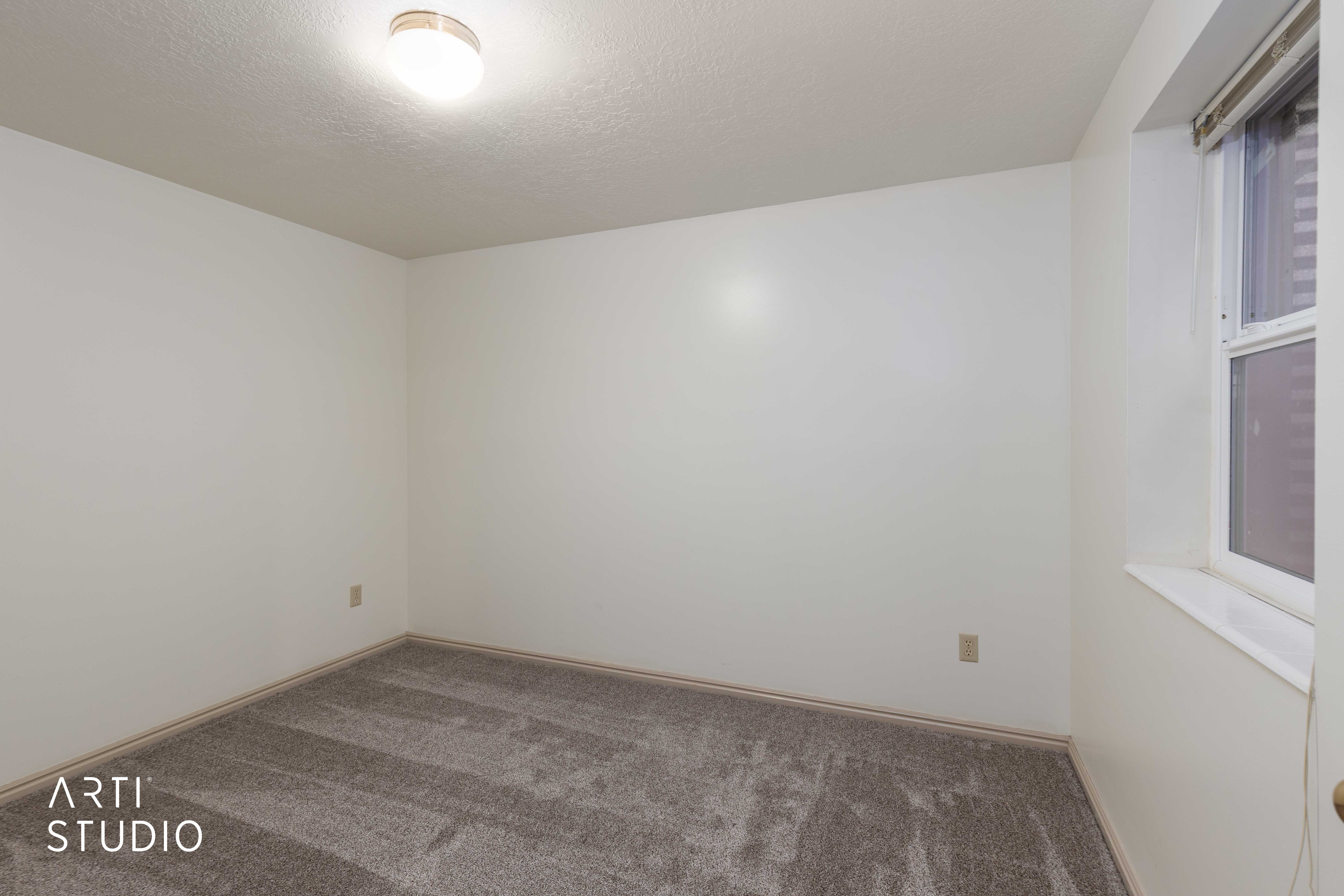 Carpeted spare room featuring a textured ceiling and baseboards