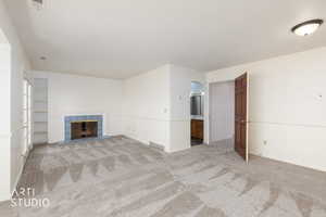 Main Bedroom featuring light carpet and a tiled fireplace