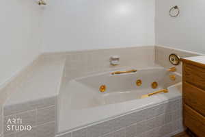 Full bath with a jetted tub and vanity