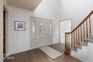 Foyer entrance featuring dark wood-style flooring and a high ceiling