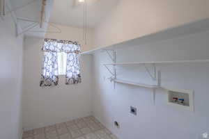 Laundry room with light flooring, hookup for a washing machine, and hookup for an electric dryer