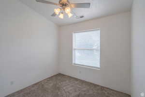 Spare room featuring carpet and a ceiling fan