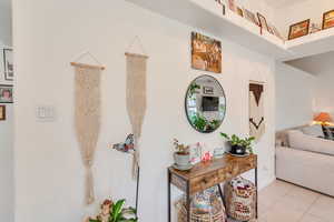 Hall featuring light tile patterned floors and baseboards