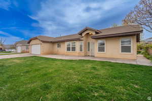 Single story home with a front lawn, stucco siding, and an attached garage