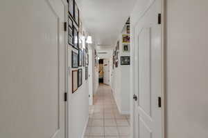 Corridor featuring light tile patterned floors and baseboards