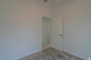 Unfurnished room featuring light colored carpet and ceiling fan