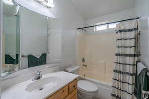 Full bathroom with vanity, lofted ceiling, and shower / tub combo with curtain