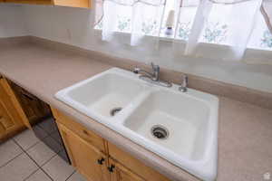 Kitchen view of light countertops and dishwasher