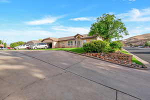 Ranch-style home featuring a mountain view, stucco siding, and a front yard