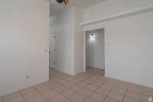 Spare room featuring light tile patterned flooring and baseboards