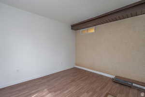 Unfurnished room featuring wood finished floors and baseboards