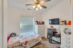 Bedroom featuring a ceiling fan, dark carpet, and lofted ceiling