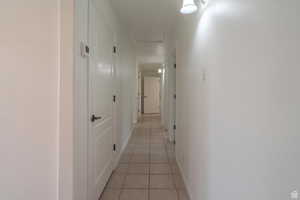 Corridor with light tile patterned floors and baseboards