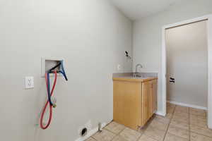 Laundry room with cabinet and sink and gas hookup for dryer