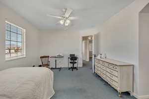 Carpeted bedroom featuring a ceiling fan and baseboards