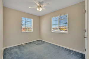 Spare room featuring carpet floors and a ceiling fan