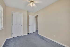 Unfurnished bedroom featuring carpet and a ceiling fan