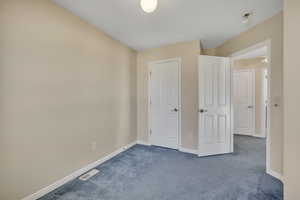Unfurnished bedroom with carpet flooring and baseboards