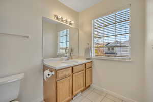Half bath with vanity and light tile patterned flooring