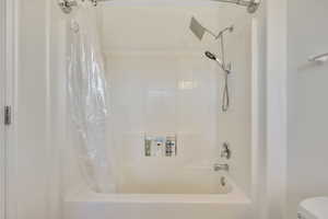 Full bath with toilet and shower / tub combo with curtain
