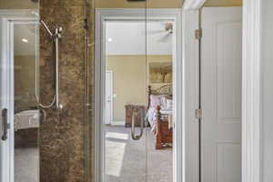 Bathroom featuring a shower stall and light carpet