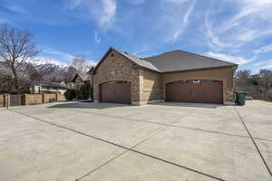 View of side of home featuring concrete driveway, an attached garage, and stucco siding