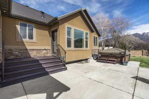 Doorway to property featuring a hot tub, stucco siding, a patio area, and a mountain view