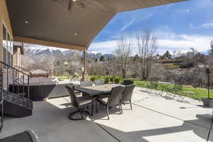 View of patio featuring an outdoor living / dining area, a mountain view, and ceiling fan