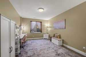 Carpeted office space with baseboards and a textured ceiling