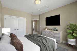 Bedroom with light carpet and a closet