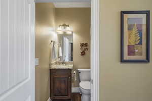 Half bath with vanity and dark wood-style floors