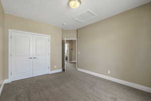 Unfurnished bedroom with carpet flooring and a closet